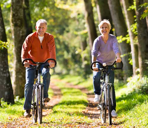 a photo of an elderly couple riding bikes
